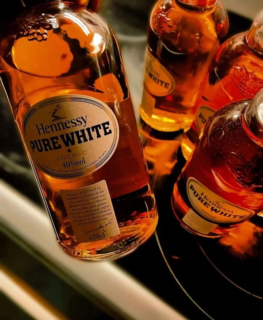 Bottles of Hennessy Pure White glowing amber in close-up