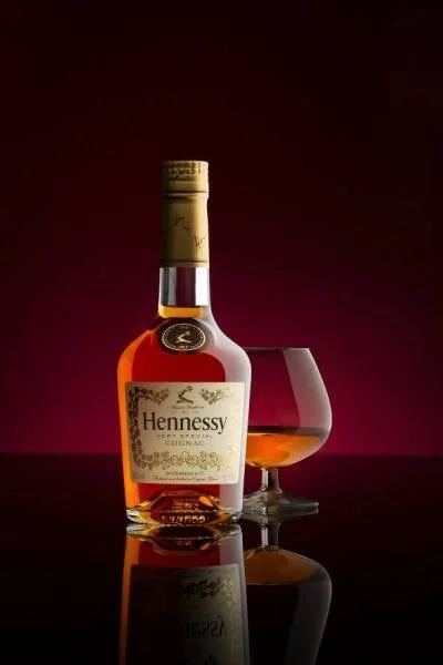 Hennessy V.S beside a snifter of cognac against a deep red backdrop